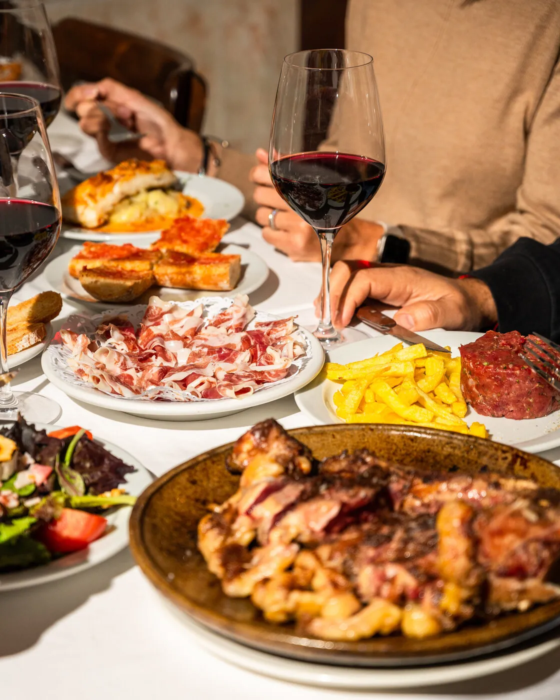 Shared table with dishes and glasses of wine