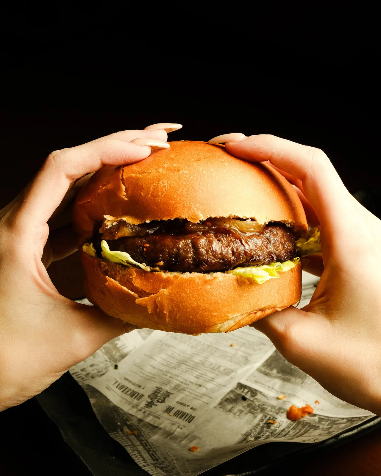 Manos sujetando una hamburguesa