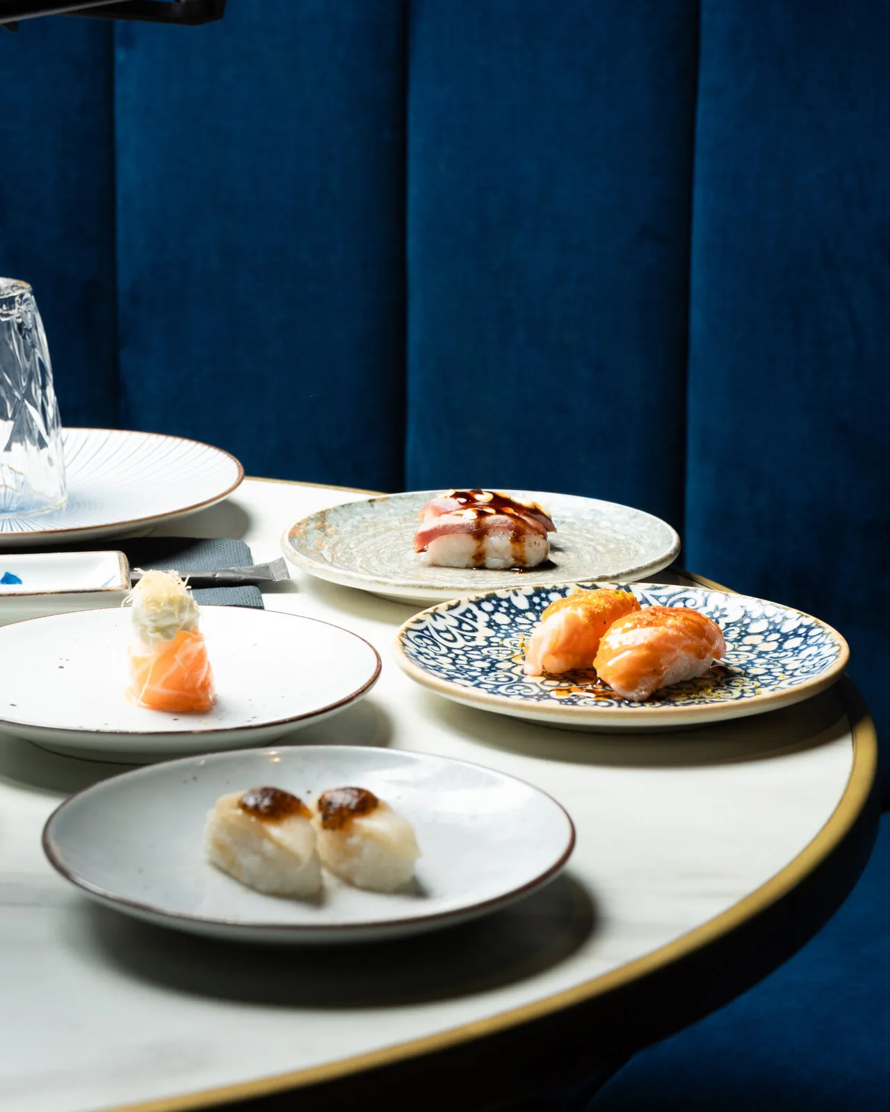 Round table with sushi on a blue sofa